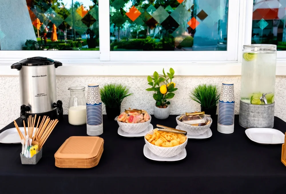 Mesa de postres y barra de dulces gourmet con torre de donas y cupcakes para bodas en Salón Palmasola Cancún.