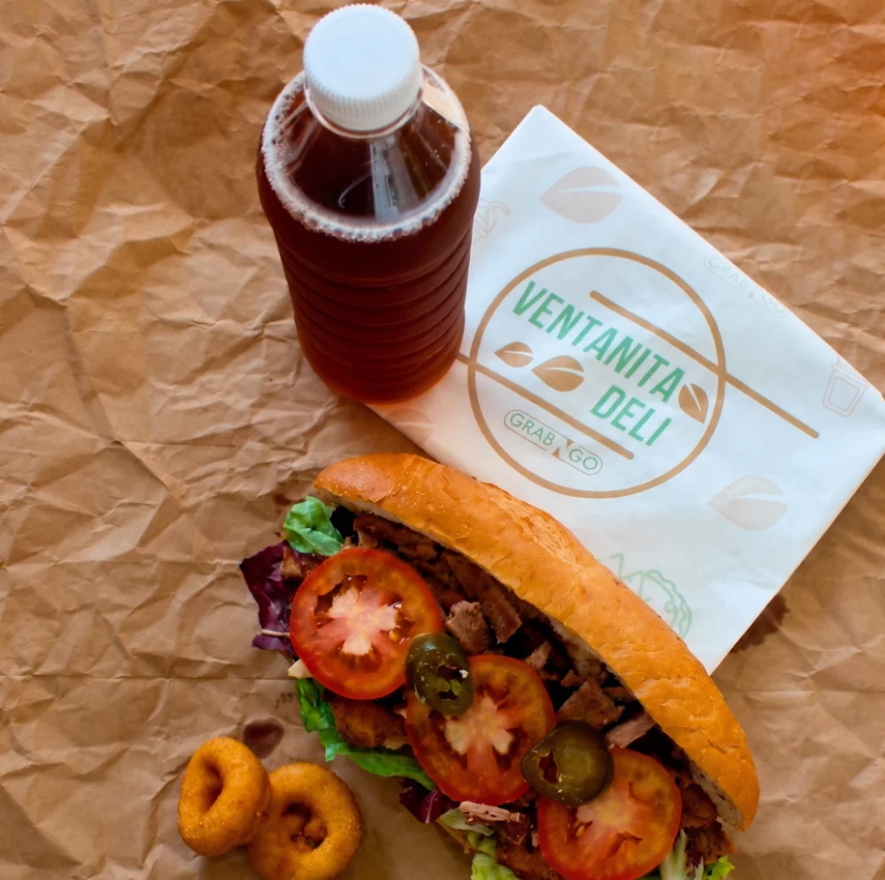 Baguette gourmet con carne, jitomate y jalapeños, aros de cebolla y bebida para el servicio de box lunch de eventos en Salón Palmasola Cancún.