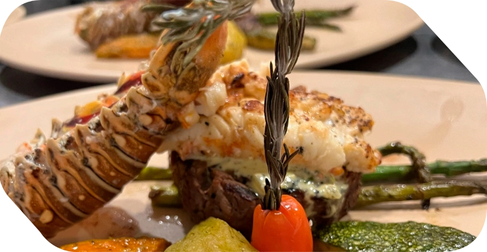 Platillo gourmet mar y tierra con cola de langosta y corte de carne para banquetes de bodas en Salón Palmasola Cancún.
