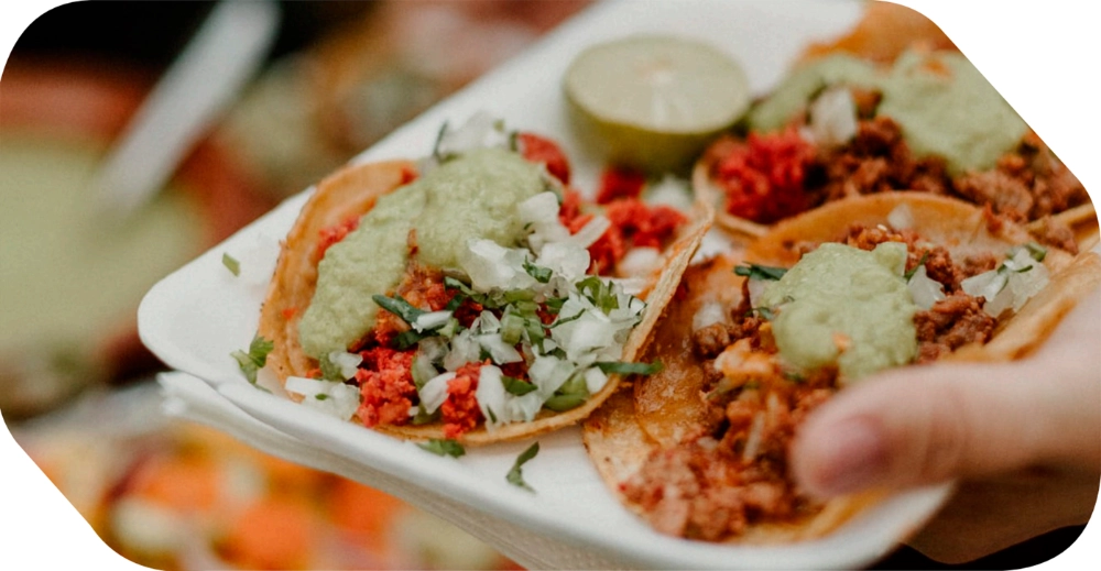 Tacos mexicanos con guacamole, cebolla y cilantro servidos en una taquiza para eventos en Salón Palmasola Cancún.