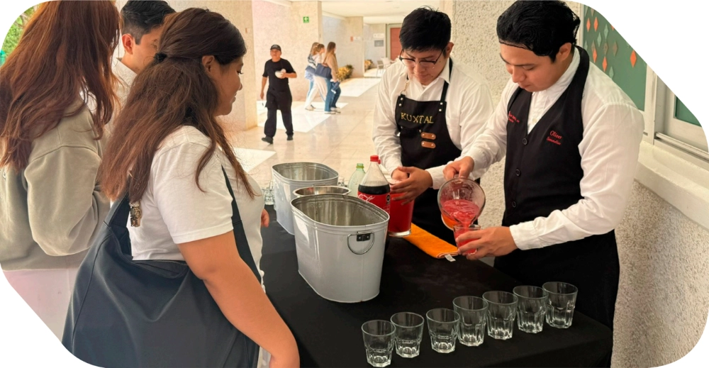 Dos mixólogos sirviendo bebidas y cócteles personalizados a asistentes en un evento social al aire libre.